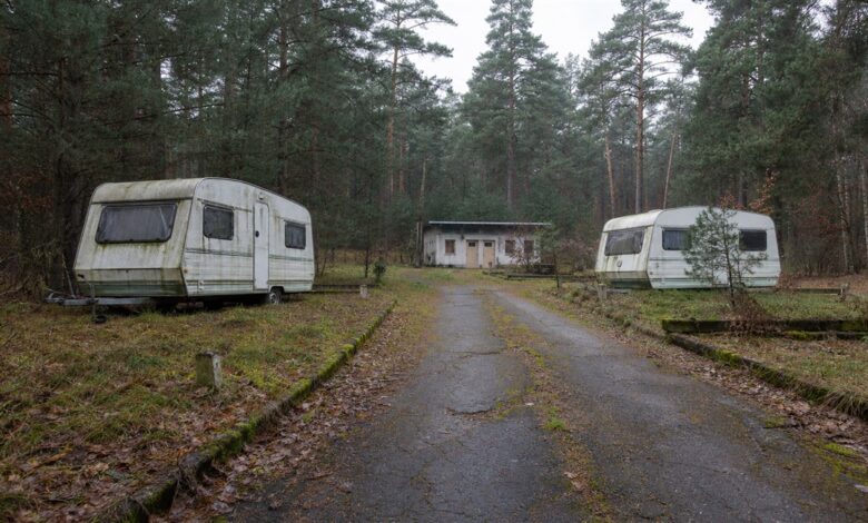 Verlassene Wohnwagen auf einem überwucherten Waldcampingplatz