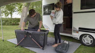 Eltern bereiten beim Camping ein Reisebett für ihr Baby vor