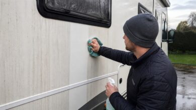 Schwarze Regenstreifen werden mit einem Mikrofasertuch vom Wohnmobil entfernt