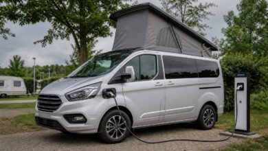 Dethleffs Globevan e.Hybrid mit geöffnetem Aufstelldach beim Laden auf einem Campingplatz