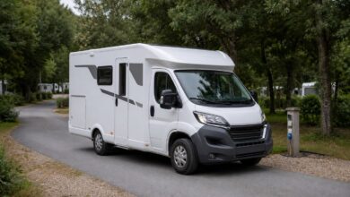 Schmales teilintegriertes Hobby Optima ONTOUR V65 GE auf einer Campingplatz-Zufahrt