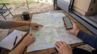 Zwei Camper planen ihre Route mit Karte und Smartphone