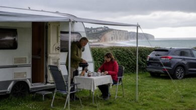 Paar frühstückt unter der Markise auf einem Campingplatz in der Normandie
