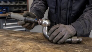 Mechaniker poliert den Kugelkopf einer abnehmbaren Anhängerkupplung