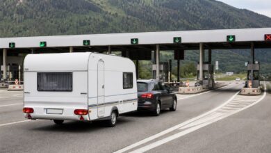 Auto mit Wohnwagen fährt in eine europäische Mautstation ein