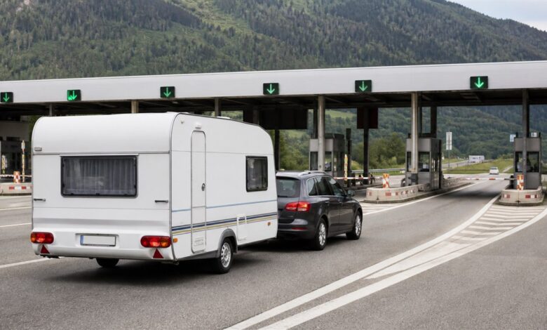 Auto mit Wohnwagen fährt in eine europäische Mautstation ein