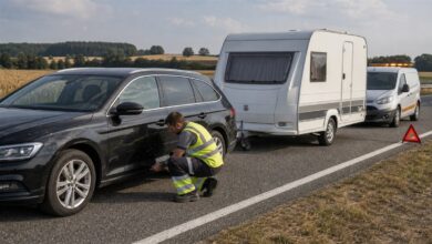 Pannenhelfer arbeitet an einem Zugfahrzeug mit angekuppeltem Wohnwagen
