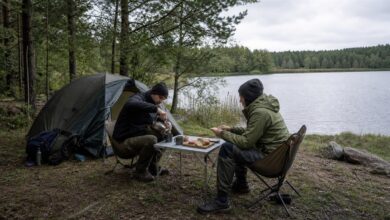 Zwei Camper frühstücken neben ihrem Zelt an einem See