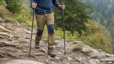 Wanderer benutzt zwei Trekkingstöcke auf einem steinigen Bergpfad