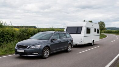 Moderner Kombi zieht einen Wohnwagen auf einer Landstraße