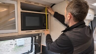 Kompakte Mikrowelle beim maßgerechten Einbau in einen Wohnmobil-Küchenschrank