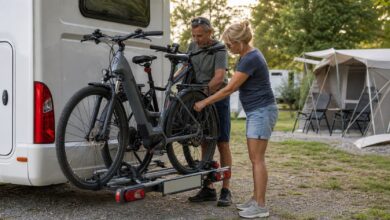 Camper sichern zwei E-Bikes auf einem Heckträger am Wohnmobil