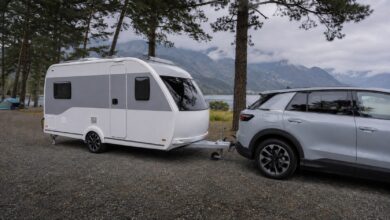 Moderner einachsiger Wohnwagen mit korrekt ausgerichteter Deichsel hinter einem Elektroauto