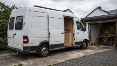 Älterer weißer Kastenwagen beim Ausbau zum Wohnmobil auf einer Einfahrt