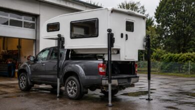 Weiße Pickup-Wohnkabine beim Aufsetzen auf einen grauen Pickup