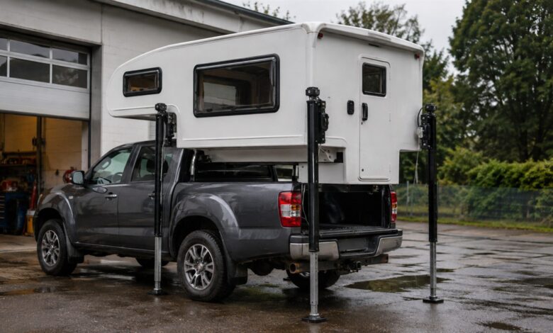 Weiße Pickup-Wohnkabine beim Aufsetzen auf einen grauen Pickup